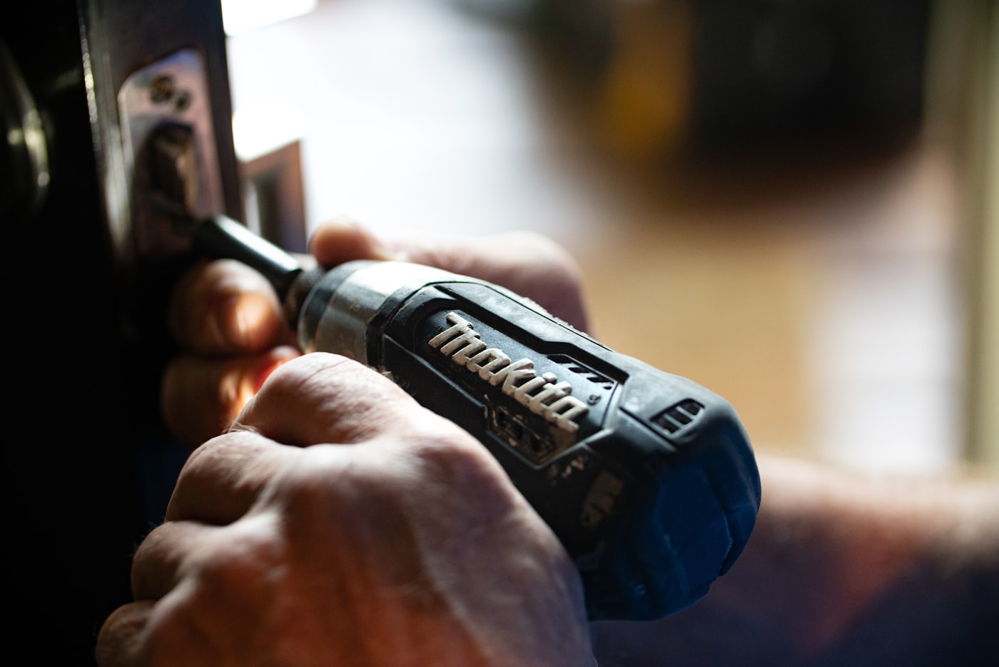 Technician using a power drill on spa equipment