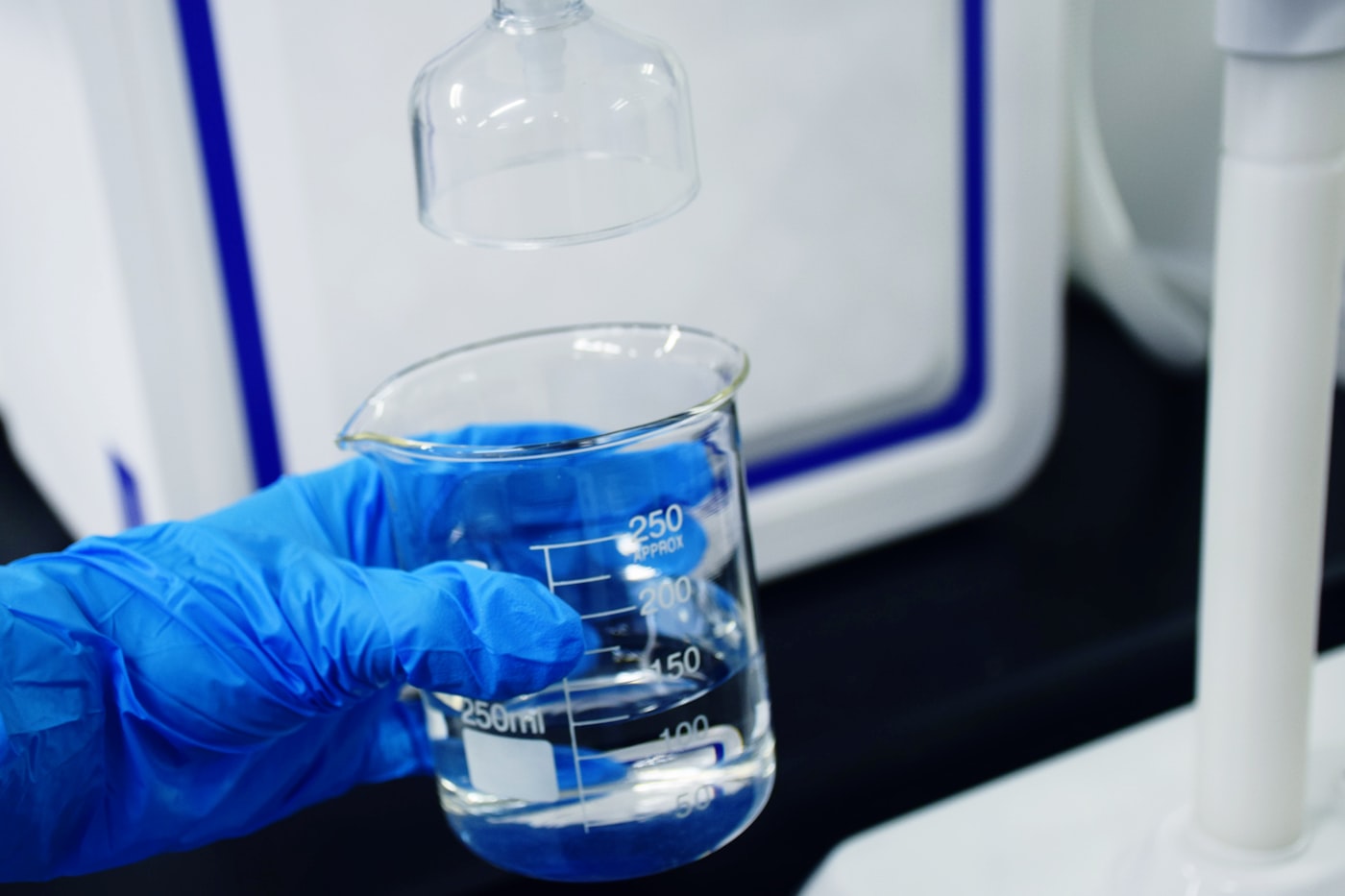 Gloved hand performing spa water chemistry test